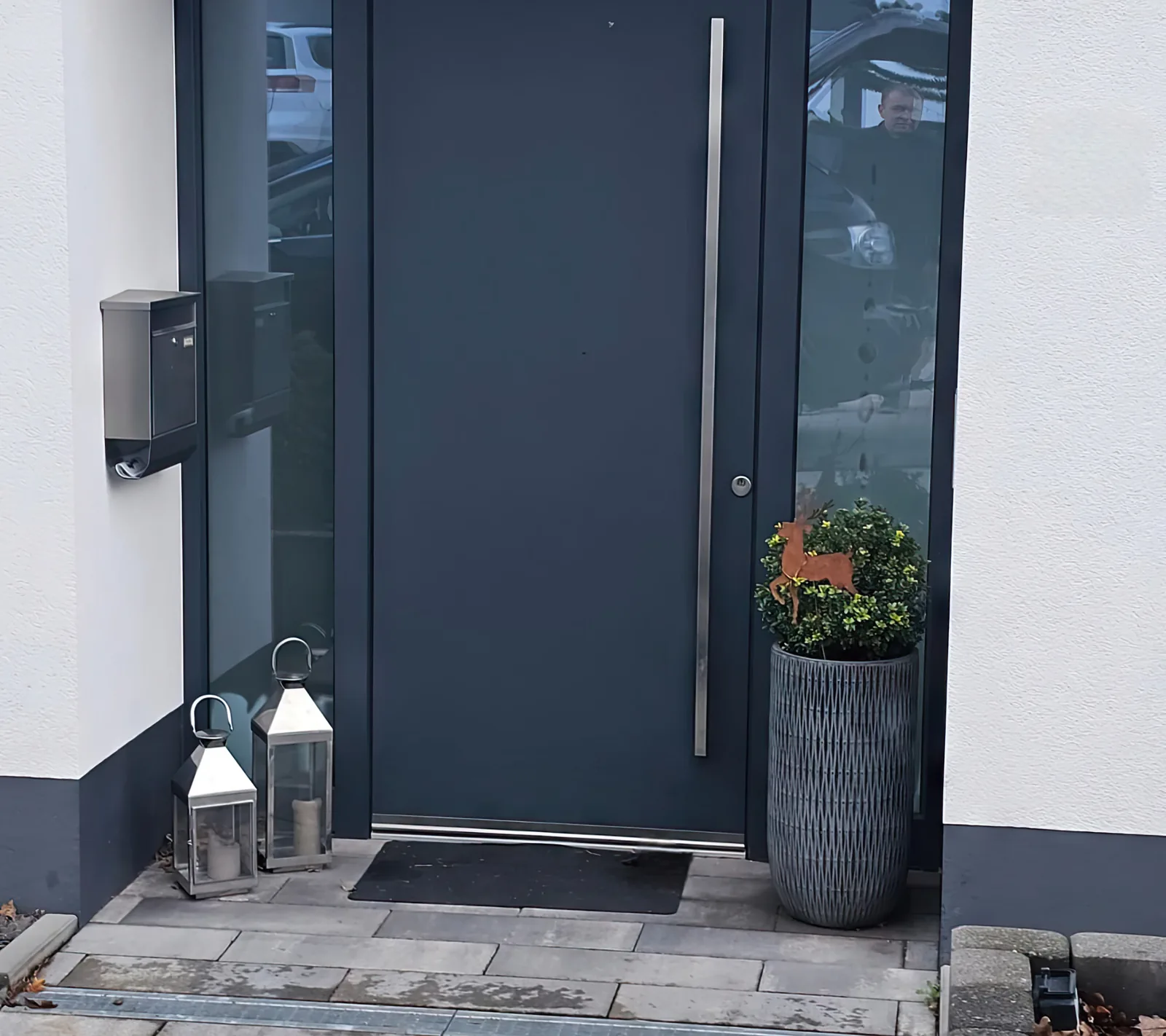 Haustür in Anthrazit mit langem Edelstahl-Stangengriff und schmalem Glasstreifen, Bann