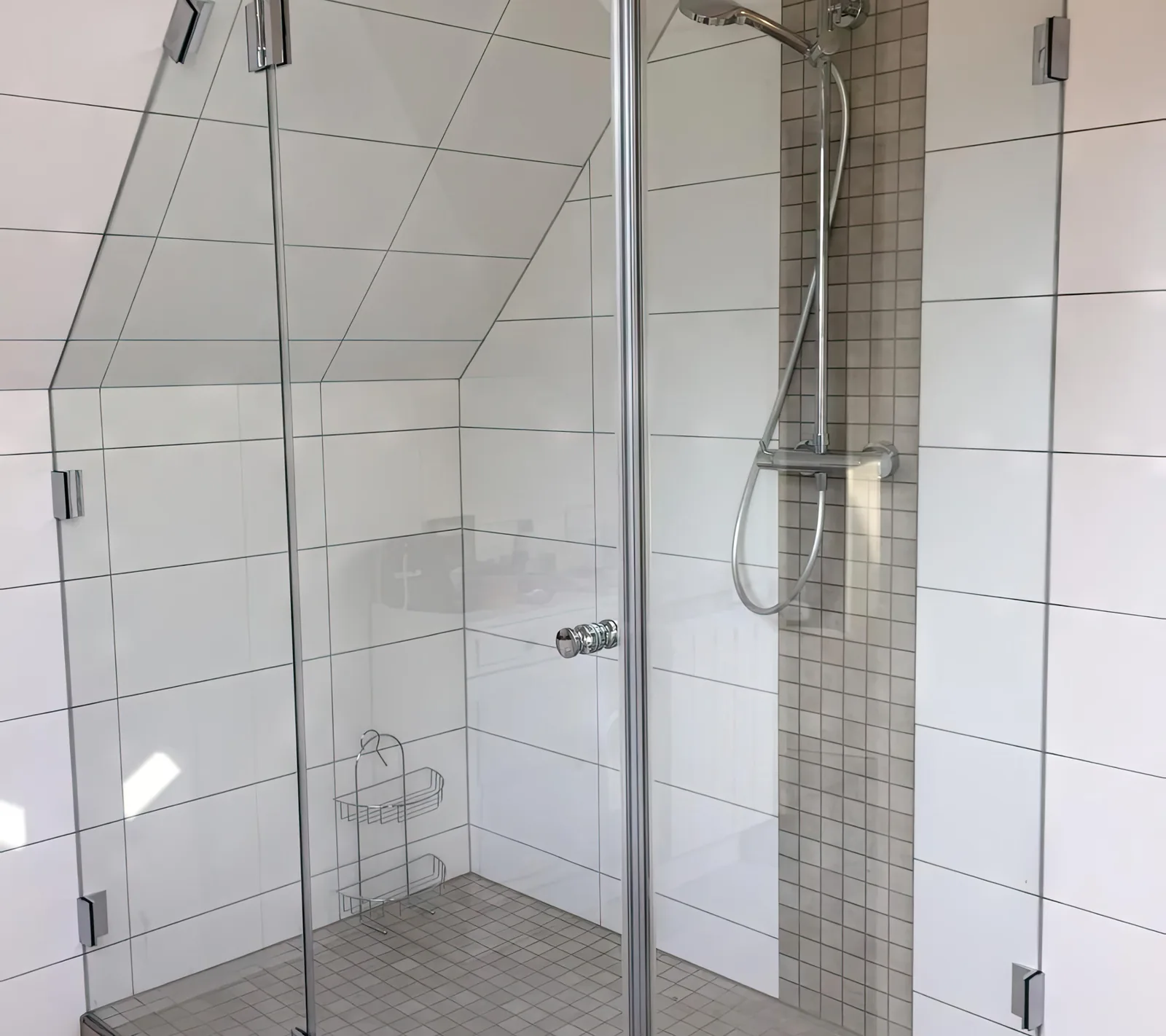 Glasdusche unter der Dachschräge mit schräg geschnittener Scheibe und Chrom-Scharnieren, weiß gefliest, St. Ingbert